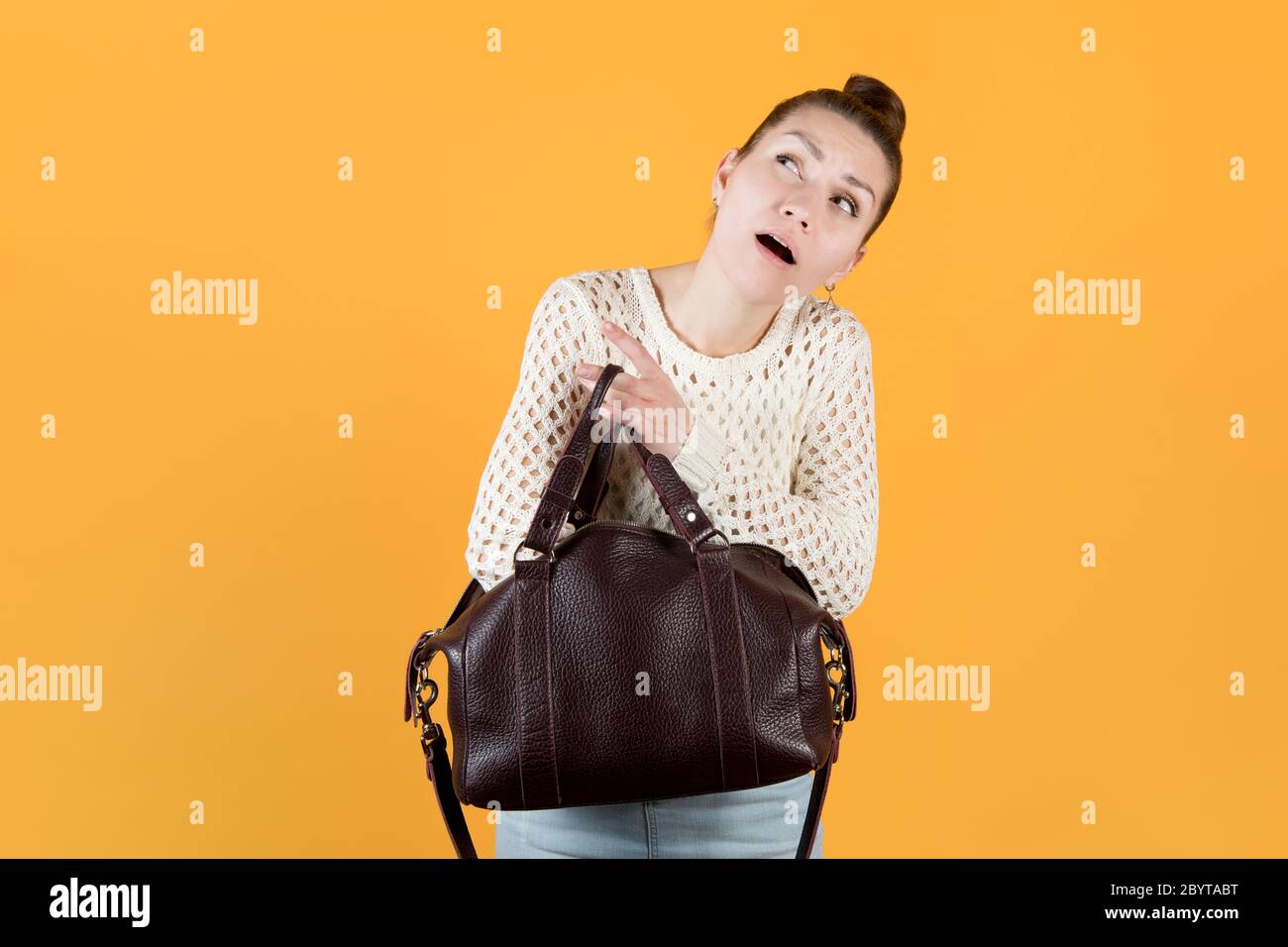 Mädchen fleißig auf der Suche nach etwas in ihrer Handtasche, suchen nach oben Stockfoto