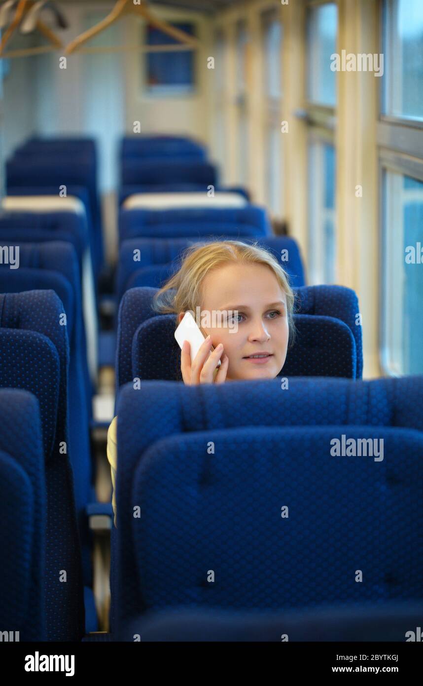 Frau sitzt in einem Zug sprechen auf ihrem Handy Stockfoto