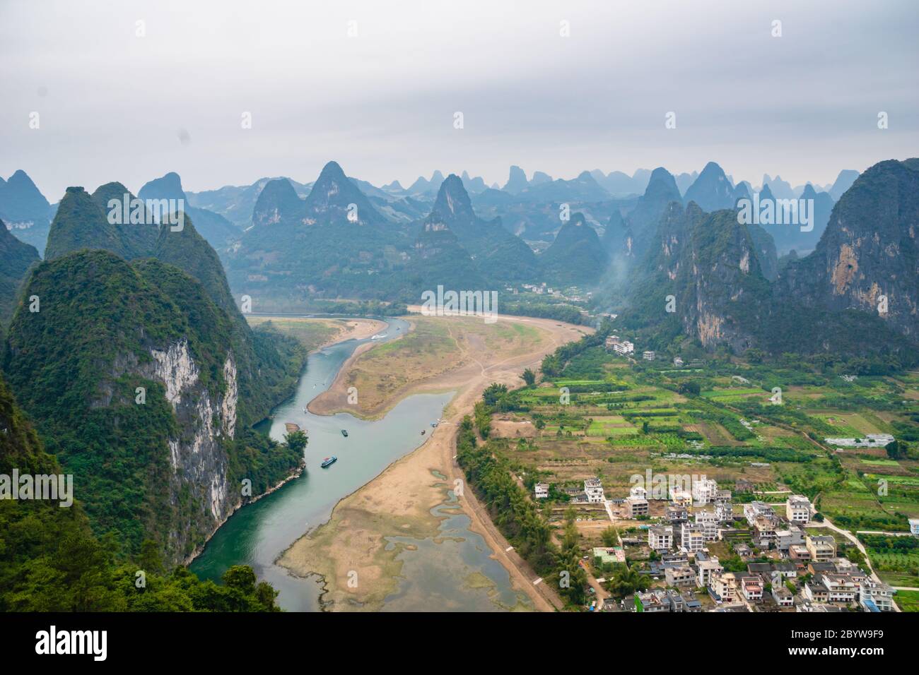 Der Blick auf den Li Fluss und Karstberge / Hügel und Kreuzfahrtschiffe in Yangshuo, Guangxi, China, einem der beliebtesten Reiseziele Chinas. Stockfoto