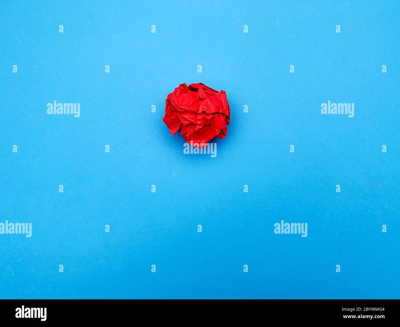 Gelungenes Ideenkonzept, rot zerknittertes Blatt Papier auf blauem Hintergrund Stockfoto