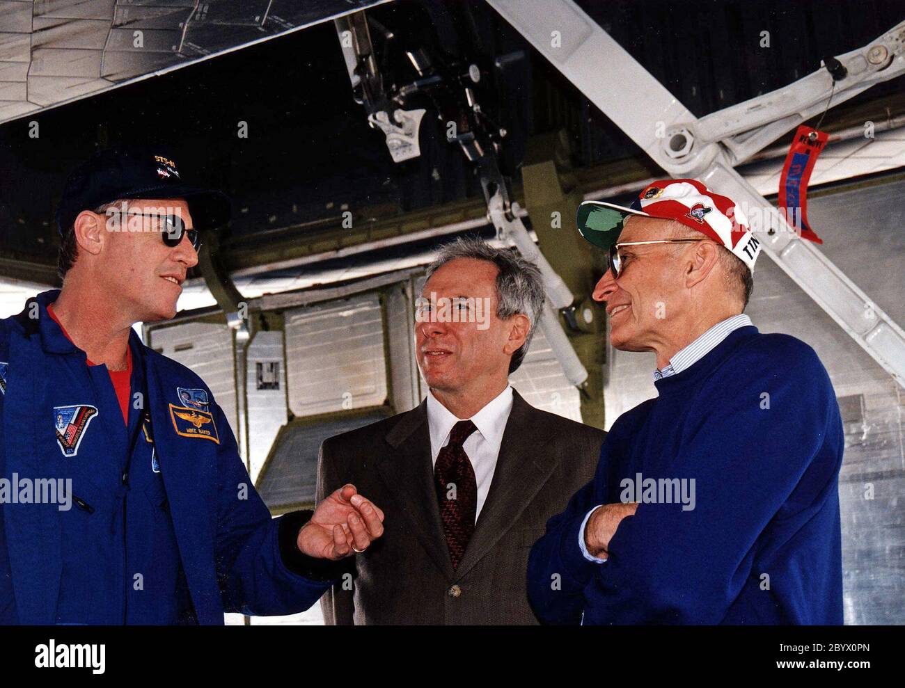 KENNEDY SPACE CENTER, FLORIDA. -- NASA-Administrator Daniel S. Goldin (Mitte) und KSC-Direktor für Shuttle-Operationen Robert B. Sieck (rechts) diskutieren mit Mission Commander Michael A. Baker (links) den erfolgreichen Abschluss der STS-81-Mission. Sie befinden sich unter dem Space Shuttle Orbiter Atlantis, nachdem das Raumflugzeug um 9:22:44 Uhr EST Jan. 22 auf der Start- und Landebahn 33 in der KSC Shuttle Landing Facility gelandet ist, um die fünfte Shuttle-mir-Andockmission zu beenden. Beim Hauptgang der Ausrüstung betrug die STS-81 Missionsdauer 10 Tage, 4 Stunden, 55 Minuten. Dies war die 34. KSC-Landung in der Shuttle-Geschichte Stockfoto
