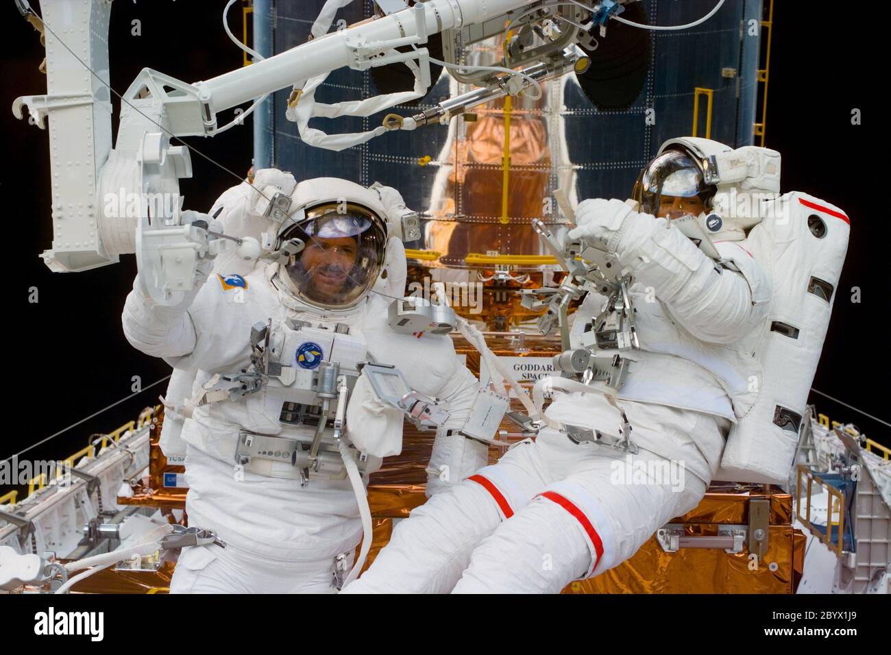 (16. Feb. 1997) --- während der dritten Extravehicular Activity (EVA), die während der Wartung des Hubble Space Telescope (HST) in der Nähe der Fußstütze des Remote Manipulator System (RMS) arbeitet, kommunizieren die Astronauten Steven L. Smith (links) und Mark C. Lee mit ihren in-Cabin-Teammitgliedern und schauen darauf zu. Diese Ansicht wurde mit einer elektronischen Standkamera (ESC) aufgenommen. Stockfoto