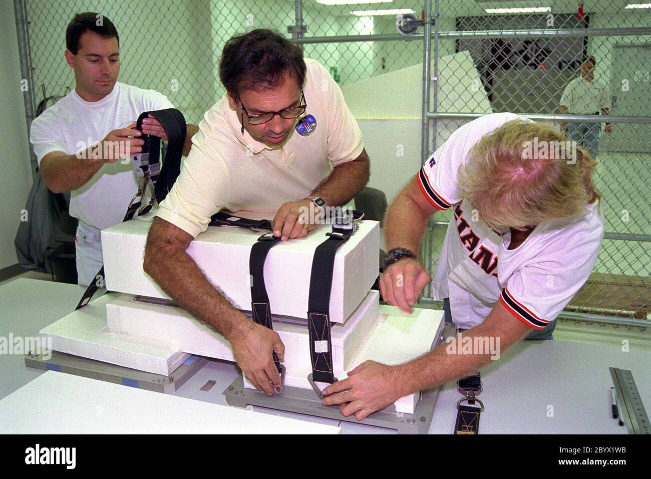 Boeing-Techniker von rechts, John Pearce Jr., Mike Vawter und Rob Ferraro bereiten einen russischen Ersatzcomputer für die Verstauung an Bord des Space Shuttle Atlantis kurz vor dem geplanten Start der Mission STS-86 vor, die als siebte Andockstelle des Space Shuttle mit der russischen Raumstation mir vorgesehen ist. Die Vorbereitungen werden in der SPACEHAB Payload Processing Facility in Cape Canaveral getroffen. Der von den Russen angeforderte Last-Minute-Ladungszuschlag wird auf der hinteren Stirnwand des SPACEHAB Doppelmoduls montiert, das als Druckbehälter für Science/logistica eingesetzt wird Stockfoto
