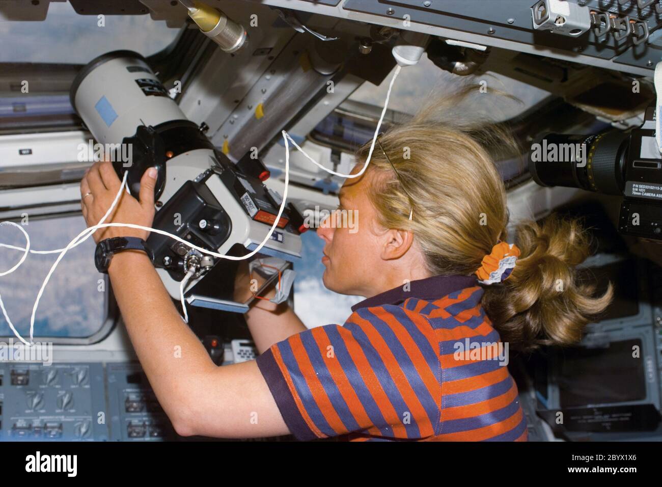 (12. August 1997) --- Astronaut N. Jan Davis, Kommandant der Nutzlast, verwendet eine großformatige Erdbeobachtungskamera durch das Dachfenster im hinteren Flugdeck des Space Shuttle Discovery. Stockfoto