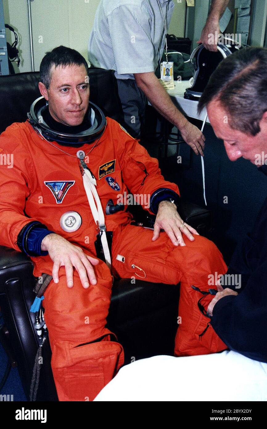 STS-81 Mission Commander Michael A. Baker wird in seinem Start-/Einstiegsanzug im Operations and Checkout (O&C) Gebäude unterstützt. Baker ist auf seinem vierten Weltraumflug und wird für die 10-tägige Mission verantwortlich sein, einschließlich der komplizierten Andock- und Abdockmanöver mit der russischen Raumstation mir. Er wird außerdem für zwei Experimente zur Risikobegrenzung an Bord verantwortlich sein und Gegenstand eines Human Life Sciences Experiments sein. Er und fünf Besatzungsmitglieder werden in Kürze das O&C verlassen und sich auf den Launch Pad 39B begeben, wo das Space Shuttle Atlantis während eines 7-minütigen Fensters abhebt, das sich öffnet Stockfoto