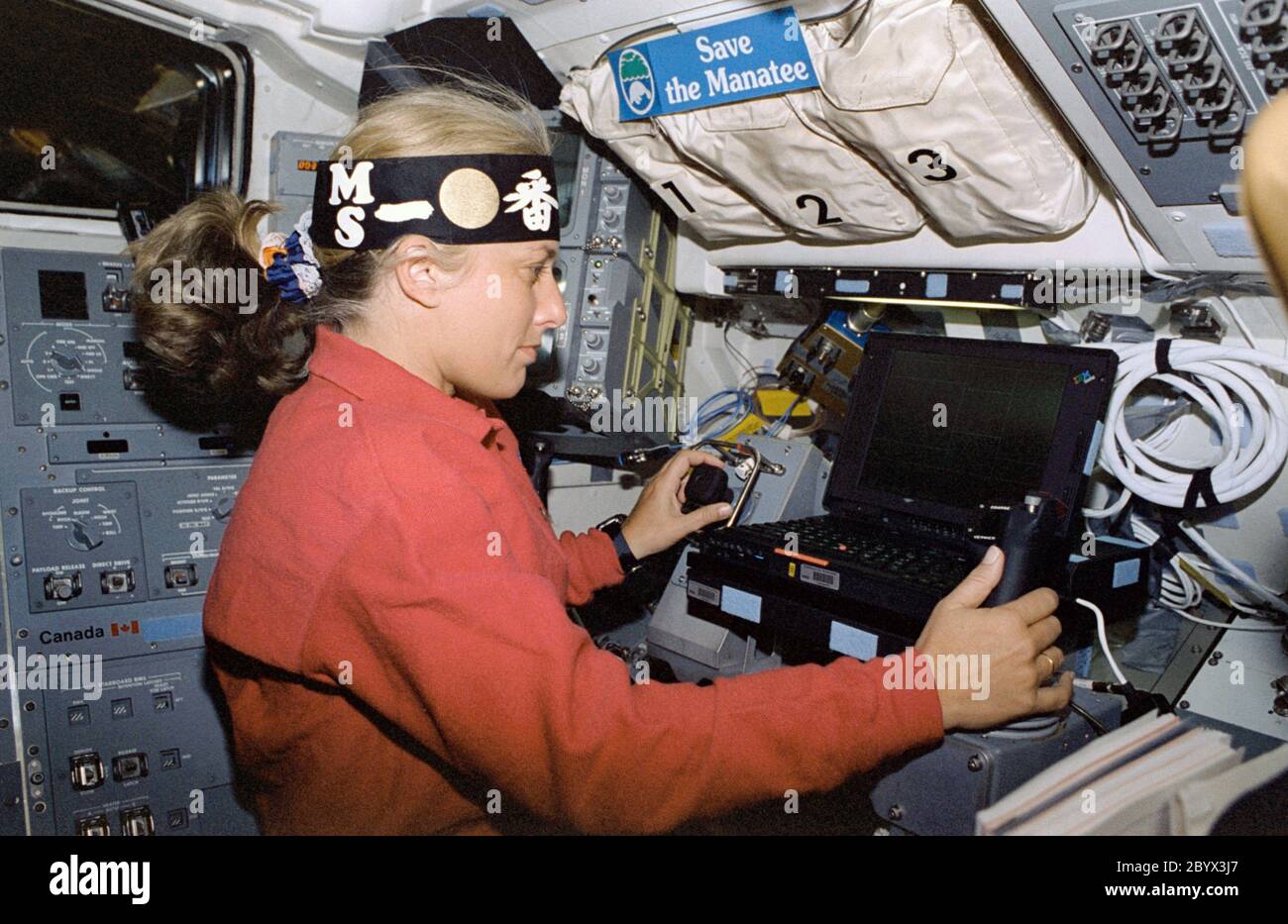 (7. - 19. August 1997) --- der Astronaut N. Jan Davis, der Kommandant der Nutzlast, führt MFD-Operationen auf der Arbeitsstation des Experiments durch, wenn er ein Stirnband trägt, das die Manipulator Flight Demonstration (MFD) Hardware mehrere Meter entfernt in der offenen Frachtschale des Space Shuttle Discovery darstellt. Dieser Flug des MFD ist in Vorbereitung für das japanische Experiment Module (JEM) Remote Manipulator System (RMS) Small Fine Arm (SFA). Stockfoto