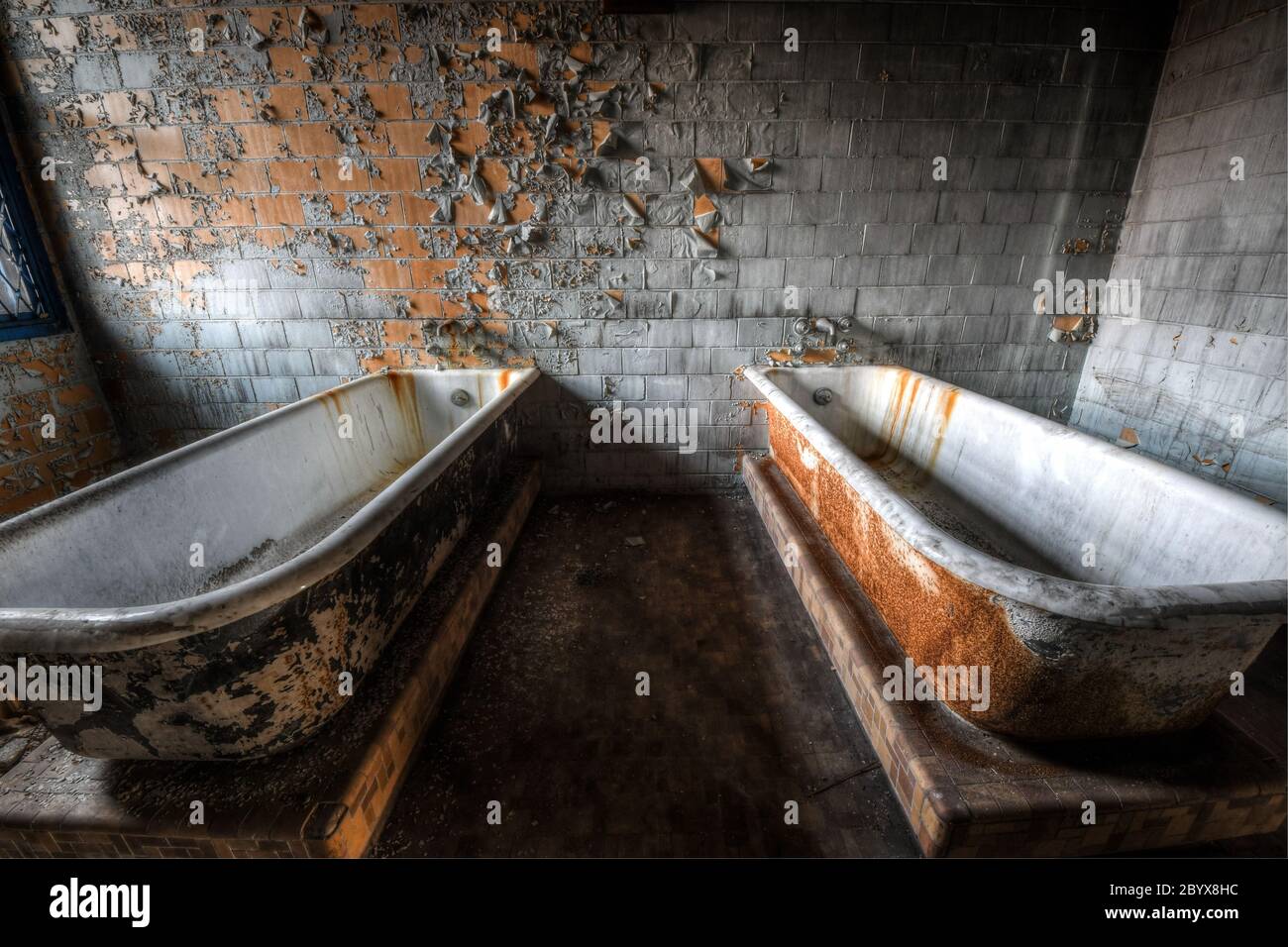 Badewannen im Hydrotherapieraum der Isolationsabteilung in einem verlassenen Krankenhaus Stockfoto