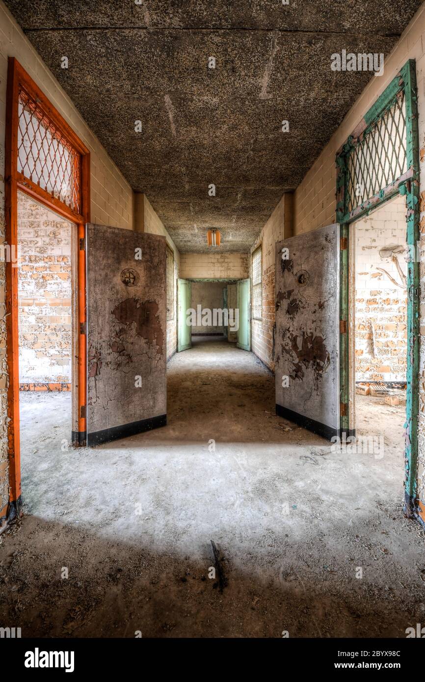 Flur mit bunten Türen in der Isolationsabteilung eines verlassenen Krankenhauses Stockfoto