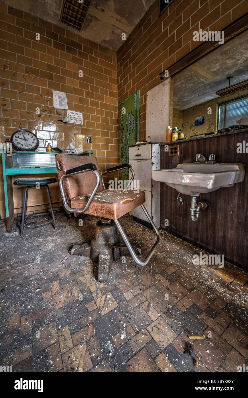 Friseursalon in einem alten verlassenen Krankenhaus mit Vintage-Salonstühlen und Haartrockner in der Zeit gefroren Stockfoto