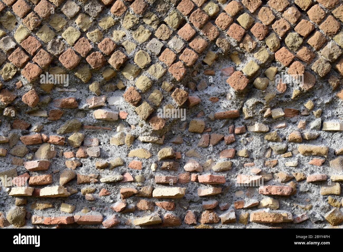 Nahaufnahme historische alte römische Mauerwerk-Bauweise, genannt Opus reticulatum, mit teilweise beschädigten Steinwand Detail Textur. Stockfoto