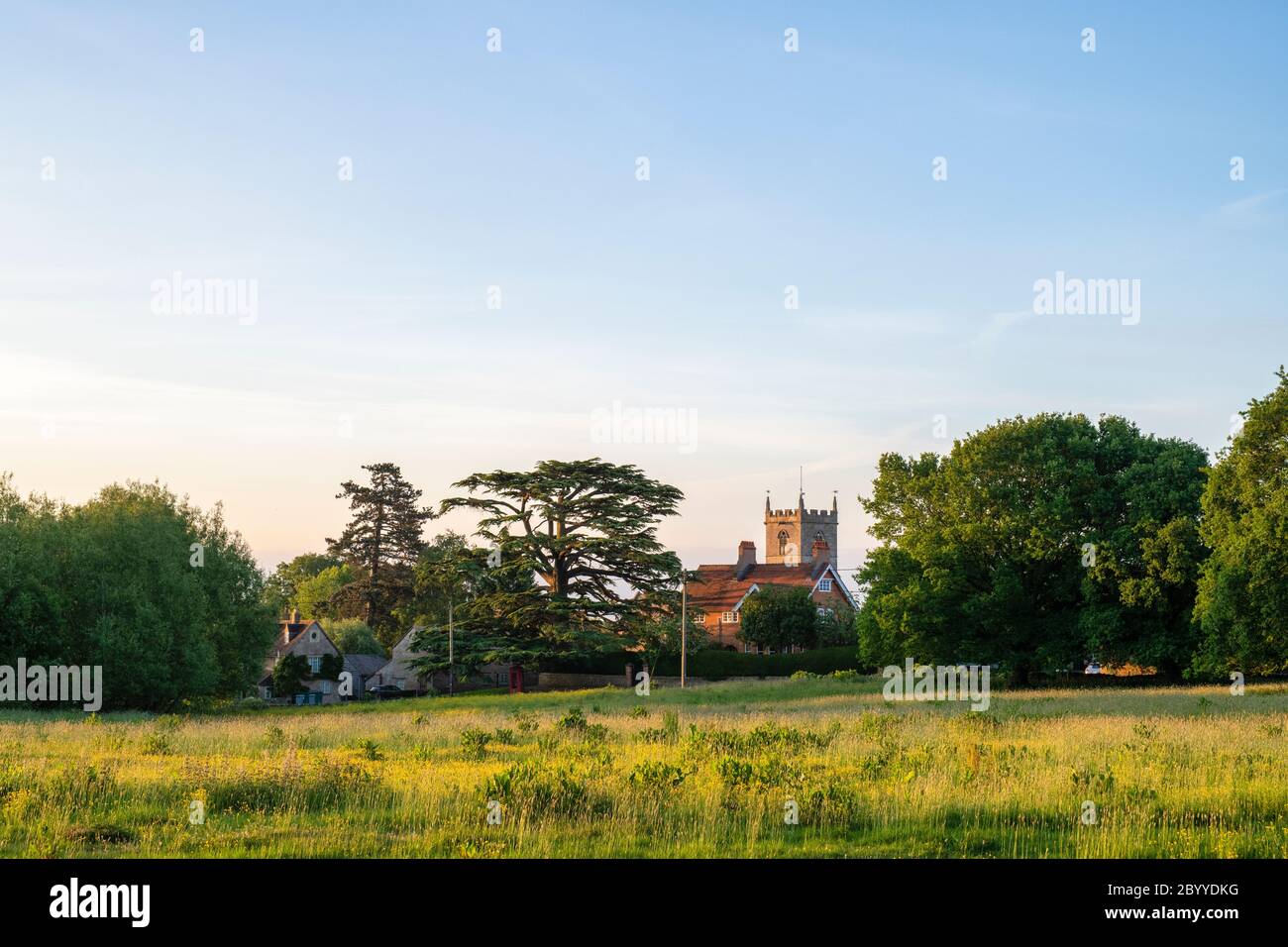 Combe Dorf mit St. Laurence Kirchturm in den frühen Morgenstunden bei Sonnenaufgang. Combe, Oxfordshire, England Stockfoto