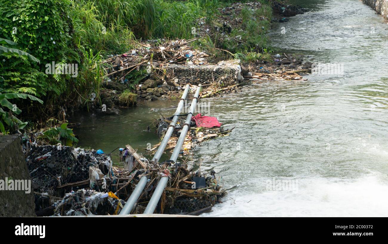 Flussufer mit Plastikmüll. Es kann nicht recycelt werden und verschmutzt die Umwelt Stockfoto