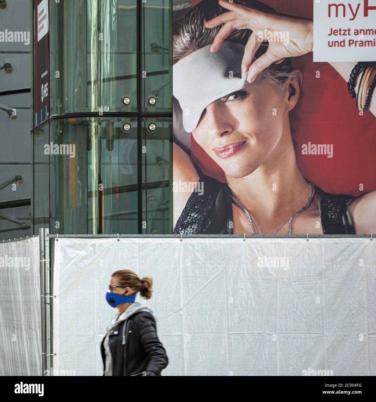 Ein Passagier mit Gesichtsmaske geht während der Sperrung durch das COVID-19-Virus in einer Schlafmaske am fast leeren Frankfurter Flughafen vorbei. Weltweit ist die Luftverkehrsbranche stark von dem massiven Rückgang des Verkehrs betroffen. Stockfoto