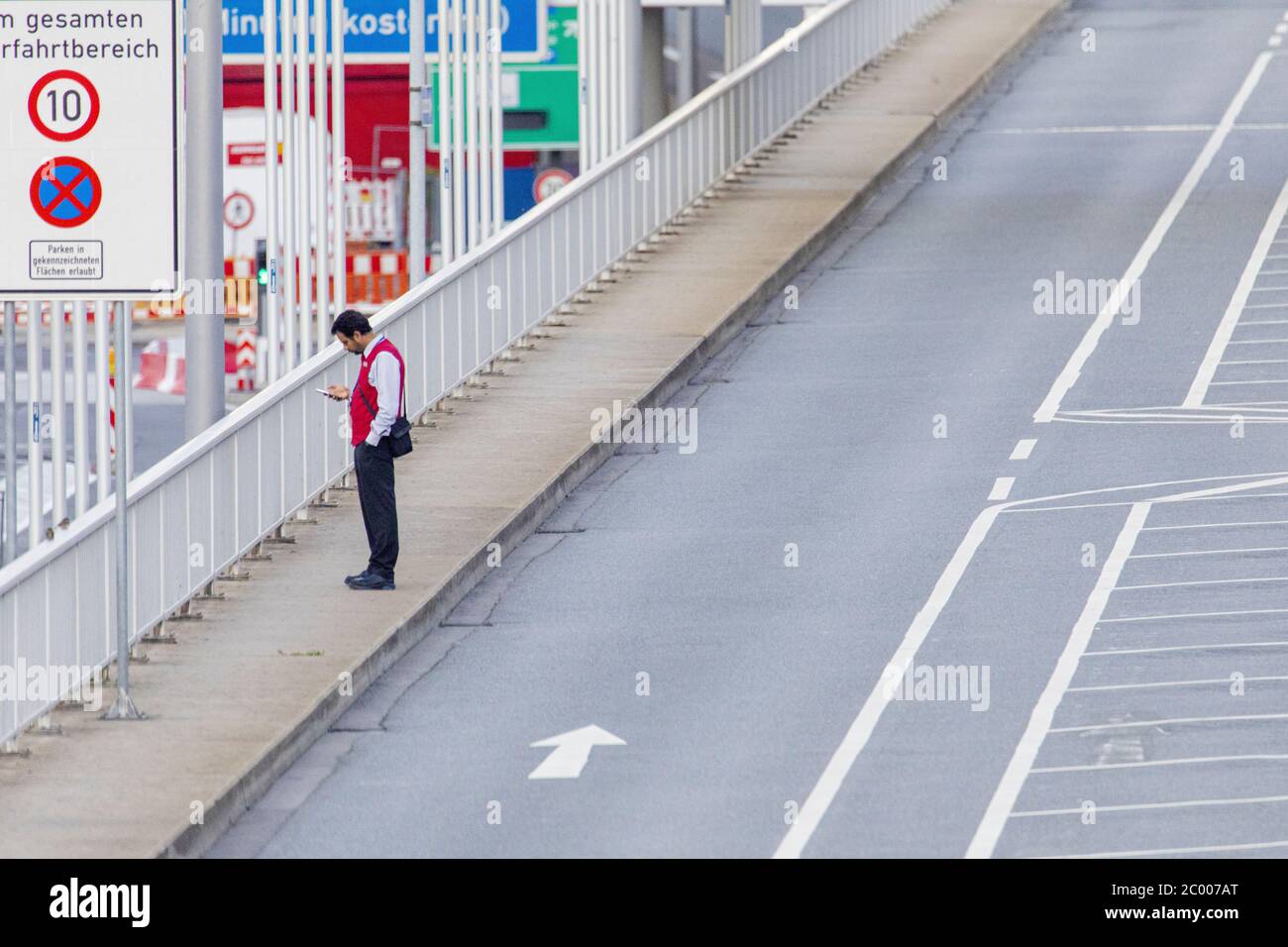 Ein Flughafenarbeiter vor dem fast leeren Frankfurter Flughafen während der Sperrung durch das COVID-19-Virus. Weltweit ist die Luftverkehrsbranche stark von dem massiven Rückgang des Verkehrs betroffen. Stockfoto