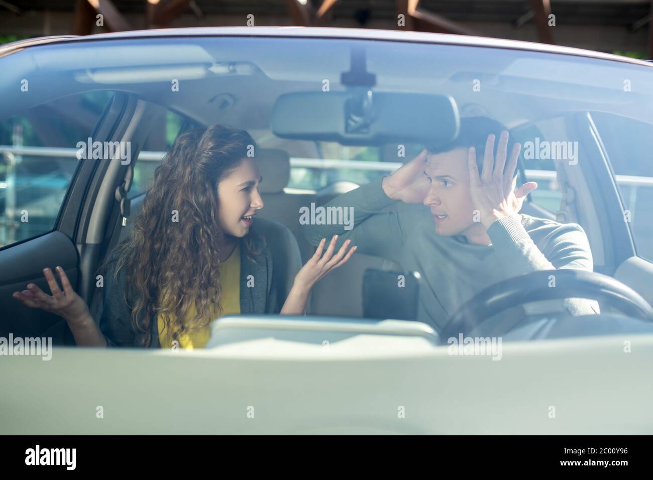 Junge Frau und Mann, die Beziehungen im Auto aussortieren Stockfoto