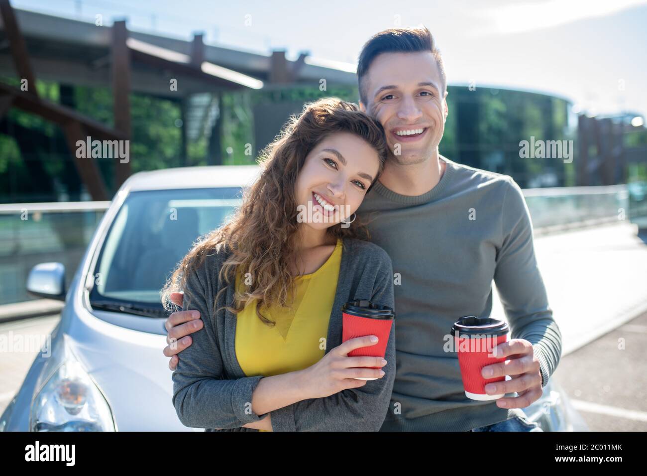 Glückliche Frau und Mann umarmen sie mit Kaffee stehen. Stockfoto