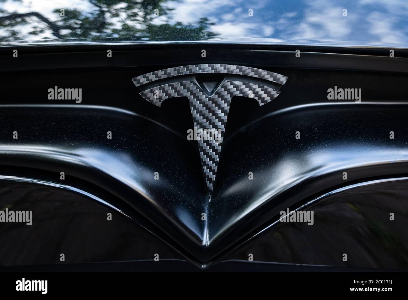 Prag, Tschechische Republik - Juni 2020: Tesla Motoren Auto Abzeichen Logo dunklen Hintergrund. Moderner Elektrofahrzeughersteller. Stockfoto