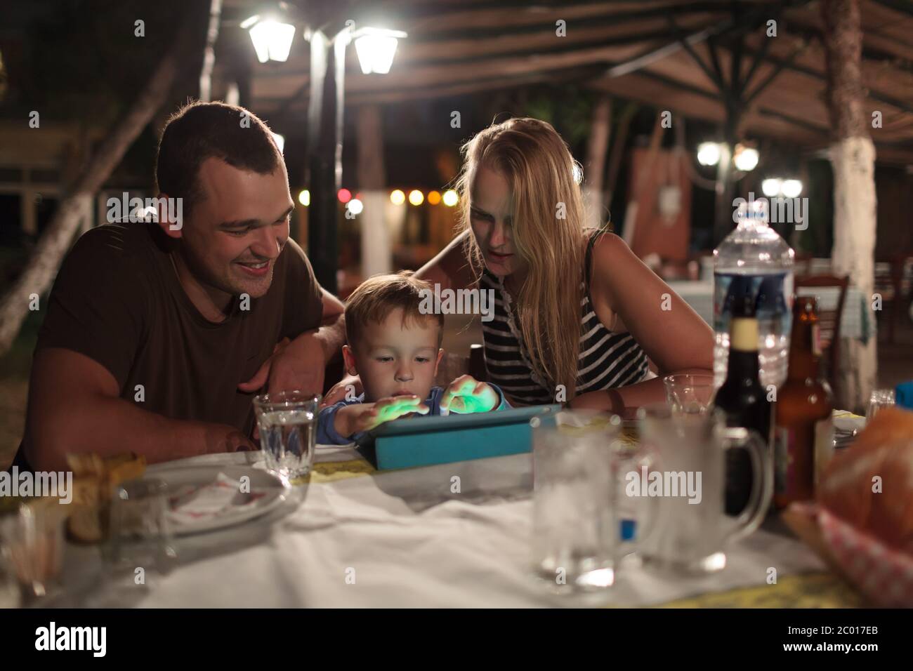 Eltern und Kind mit Tablet-PC im Café im freien Stockfoto