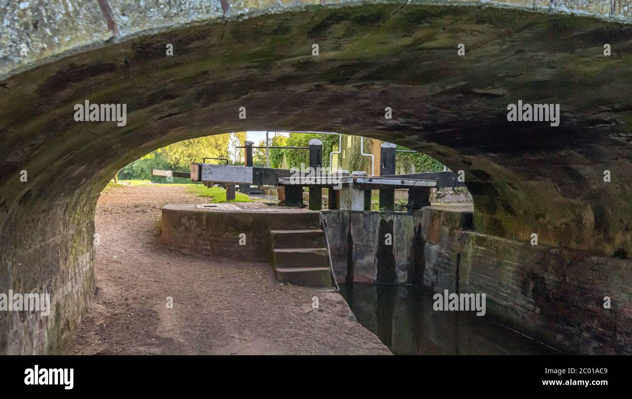 Blick unter einer Brücke auf einem Kanal auf die Schleusentore Stockfoto