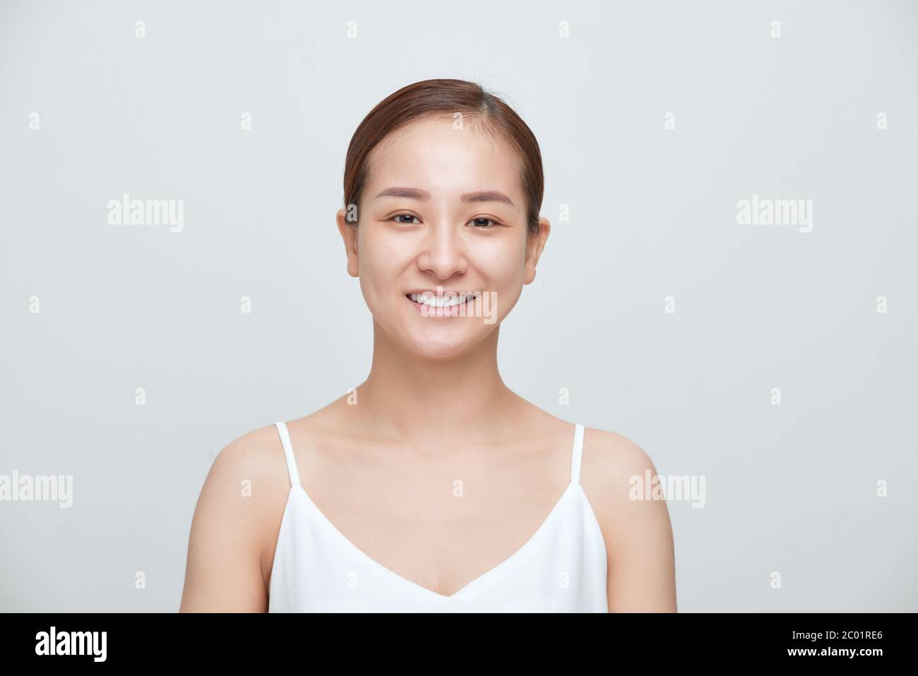 Lächeln der jungen asiatischen Frau ohne Make-up auf weißem Hintergrund Stockfoto