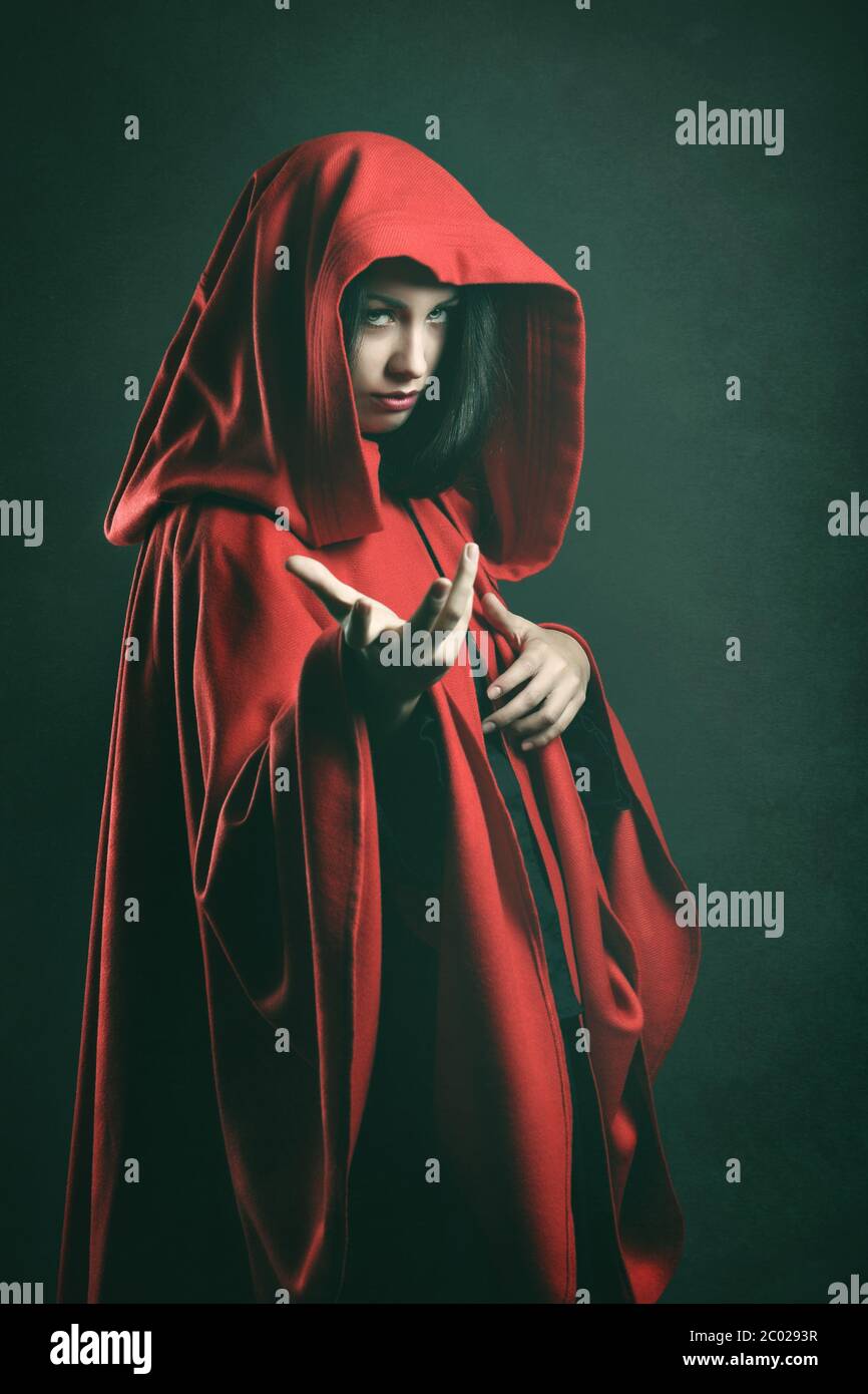 Dunkles Porträt einer schönen Frau mit rotem Umhang. Fantasy Studio gedreht Stockfoto