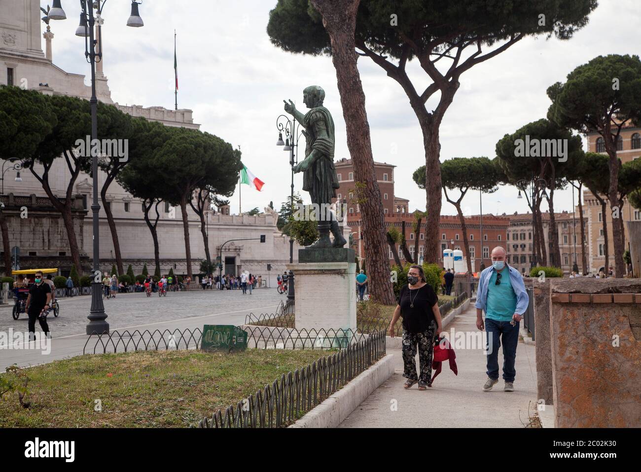 Menschen mit Schutzmaske gehen am 02. Juni 2020 entlang der Via dei Fori Imperiali im Zentrum Roms, als Italien beginnt, seine Sperre zu lockern, während das Land die Ausbreitung der COVID-19-Infektion, die durch das neuartige Coronavirus verursacht wird, eindämmen will. Stockfoto