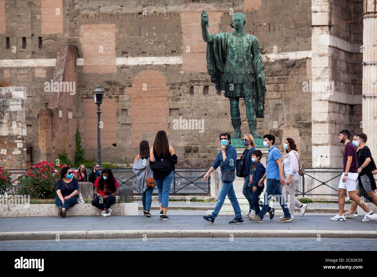 Menschen mit Schutzmaske gehen am 02. Juni 2020 entlang der Via dei Fori Imperiali im Zentrum Roms, als Italien beginnt, seine Sperre zu lockern, während das Land die Ausbreitung der COVID-19-Infektion, die durch das neuartige Coronavirus verursacht wird, eindämmen will. Stockfoto