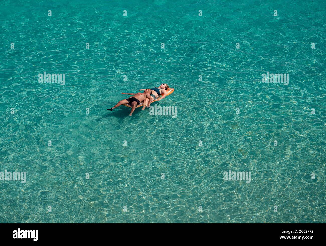 Lecce, Italien - 11. August 2018: Ein paar Menschen schwimmen auf dem blauen klaren Meer an einem sonnigen Tag im Sommerurlaub an der Küste von Lecce Stockfoto