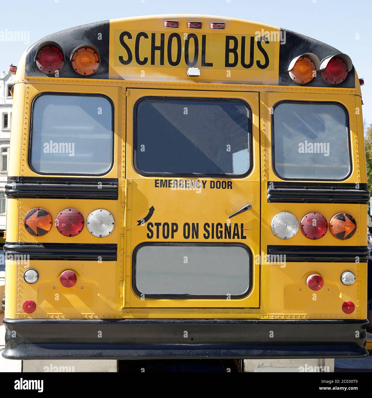 Rückansicht eines traditionellen gelben Schulbusses auf der Straße Stockfoto