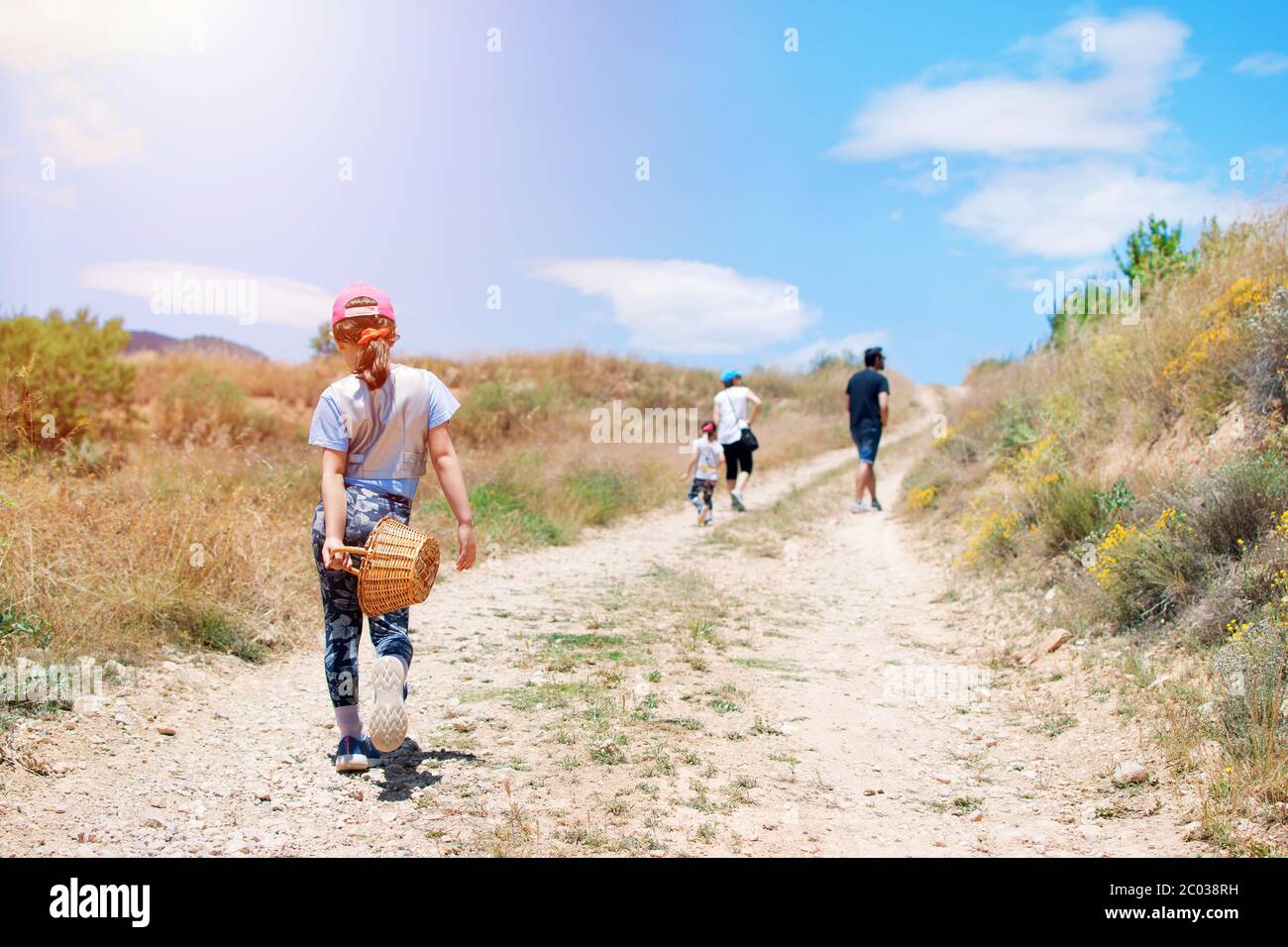 Familie mit drei Kindern Wandern im Grünen Weg in die Berge. Aktivitäten in Freiheit mit Familien. Nettes Mädchen zu Fuß durch einen Pfad Stockfoto