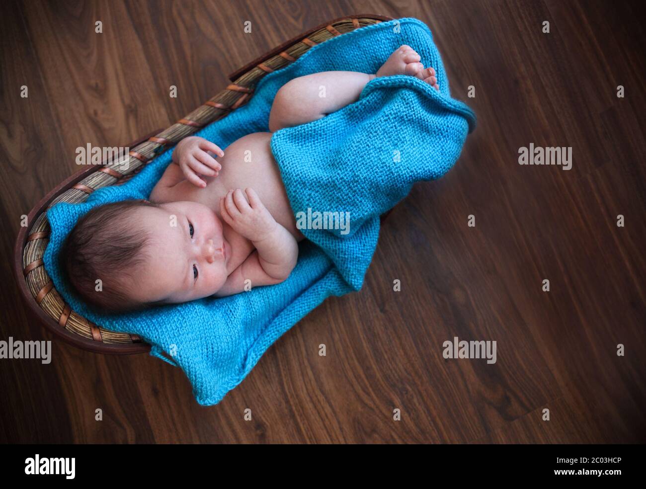 Baby Junge auf blaue Decke im Korb legen Stockfoto