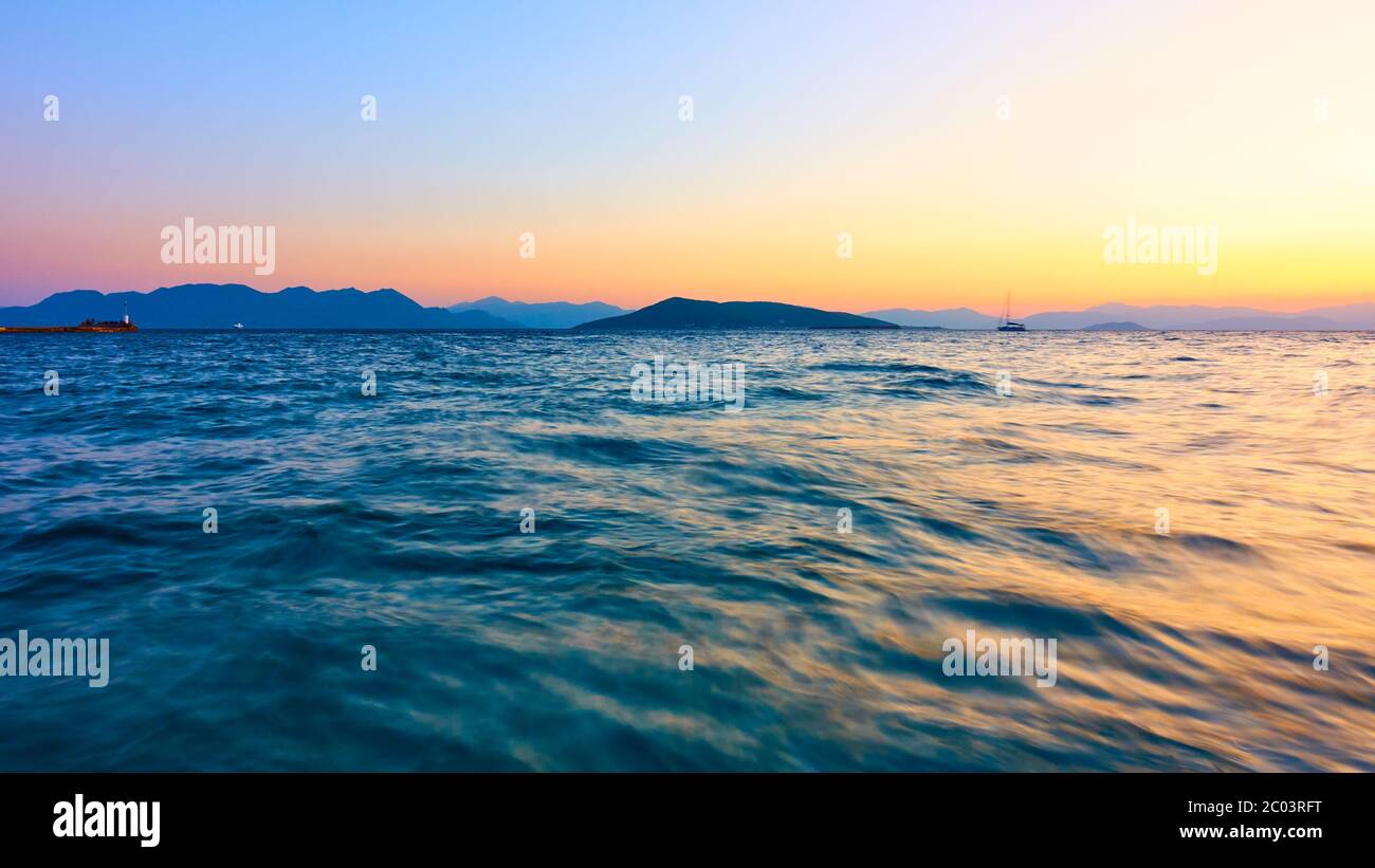 Panoramablick mit Meerwasser bei Sonnenuntergang, Griechenland - Sonnenuntergang Seesicht. Lange Exposition, das Wasser wird durch Bewegung verschwommen Stockfoto