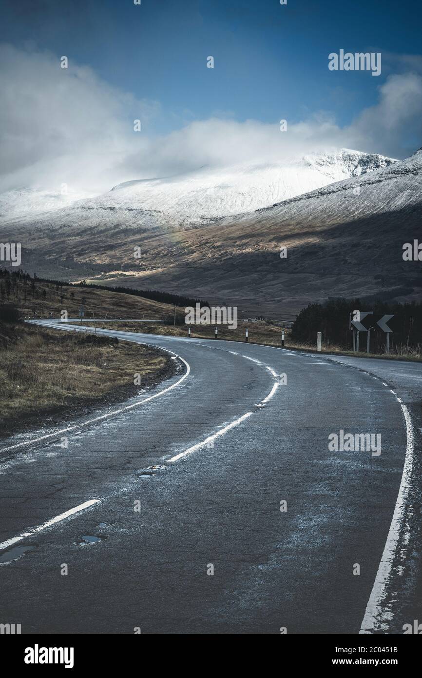 Blick auf die A82. Frühe Frühlingsberge von Schottland. Neuschnee bedeckte Bergspitzen in der Glencoe Region von Schottland. Großbritannien Stockfoto