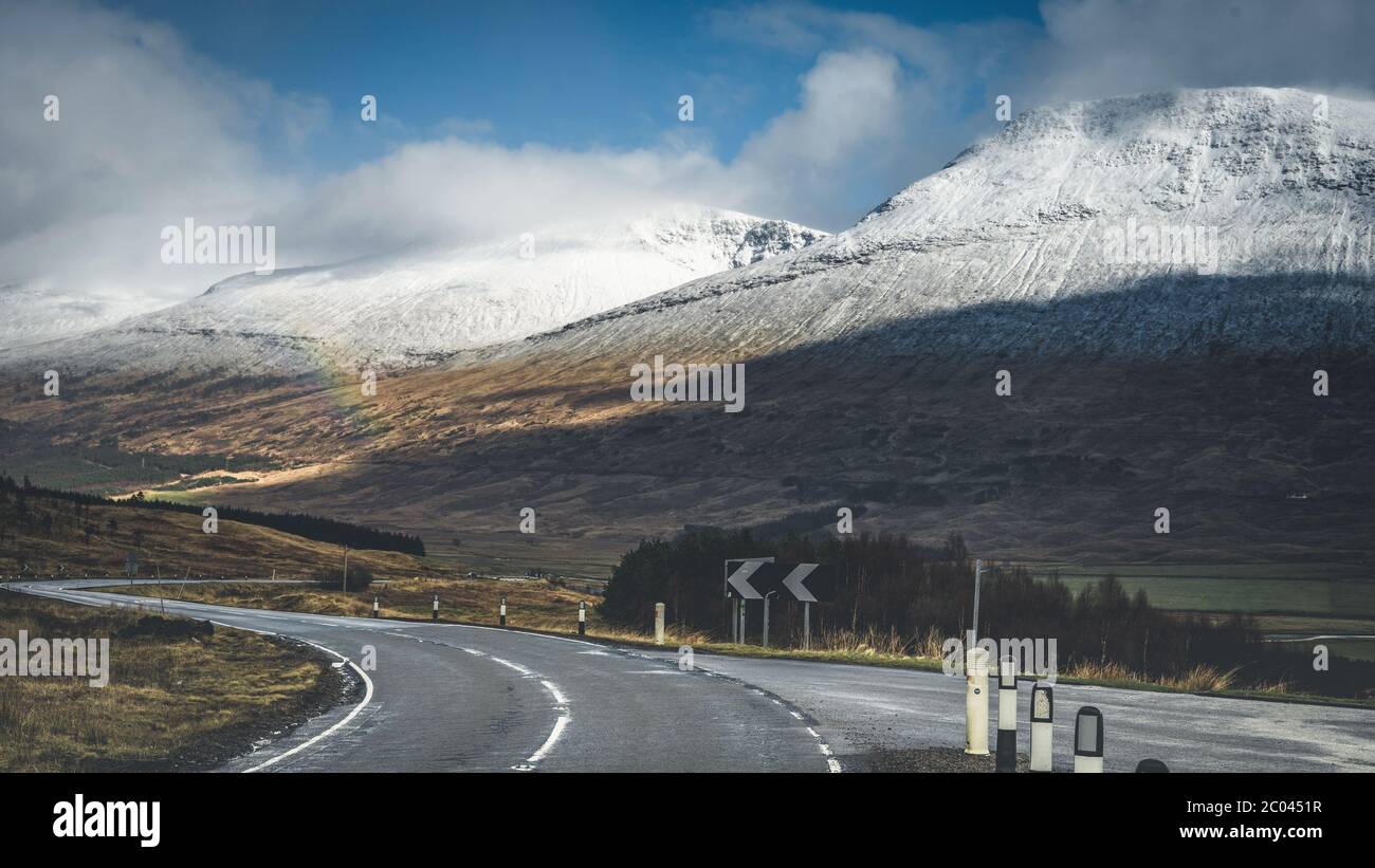 Blick auf die A82. Frühe Frühlingsberge von Schottland. Neuschnee bedeckte Bergspitzen in der Glencoe Region von Schottland. Großbritannien Stockfoto