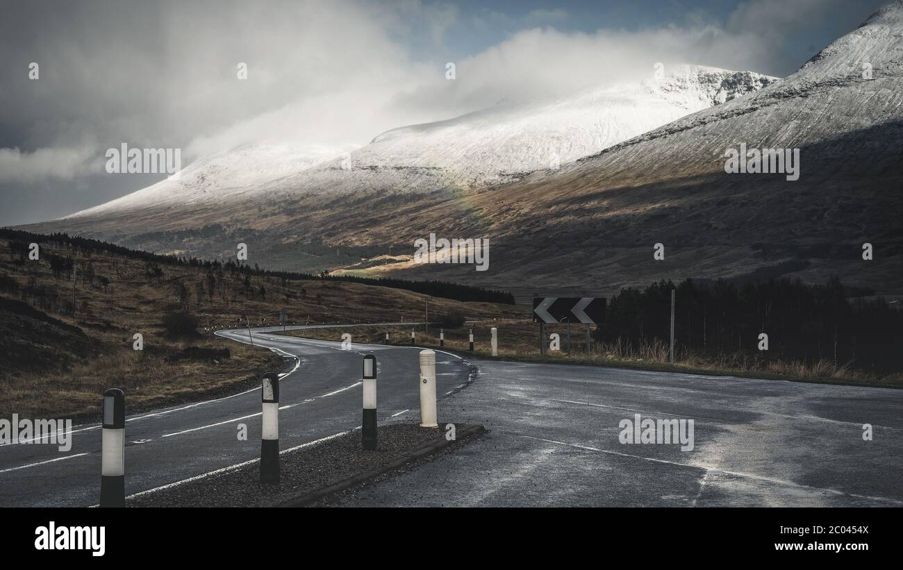 Blick auf die A82. Frühe Frühlingsberge von Schottland. Neuschnee bedeckte Bergspitzen in der Glencoe Region von Schottland. Großbritannien Stockfoto