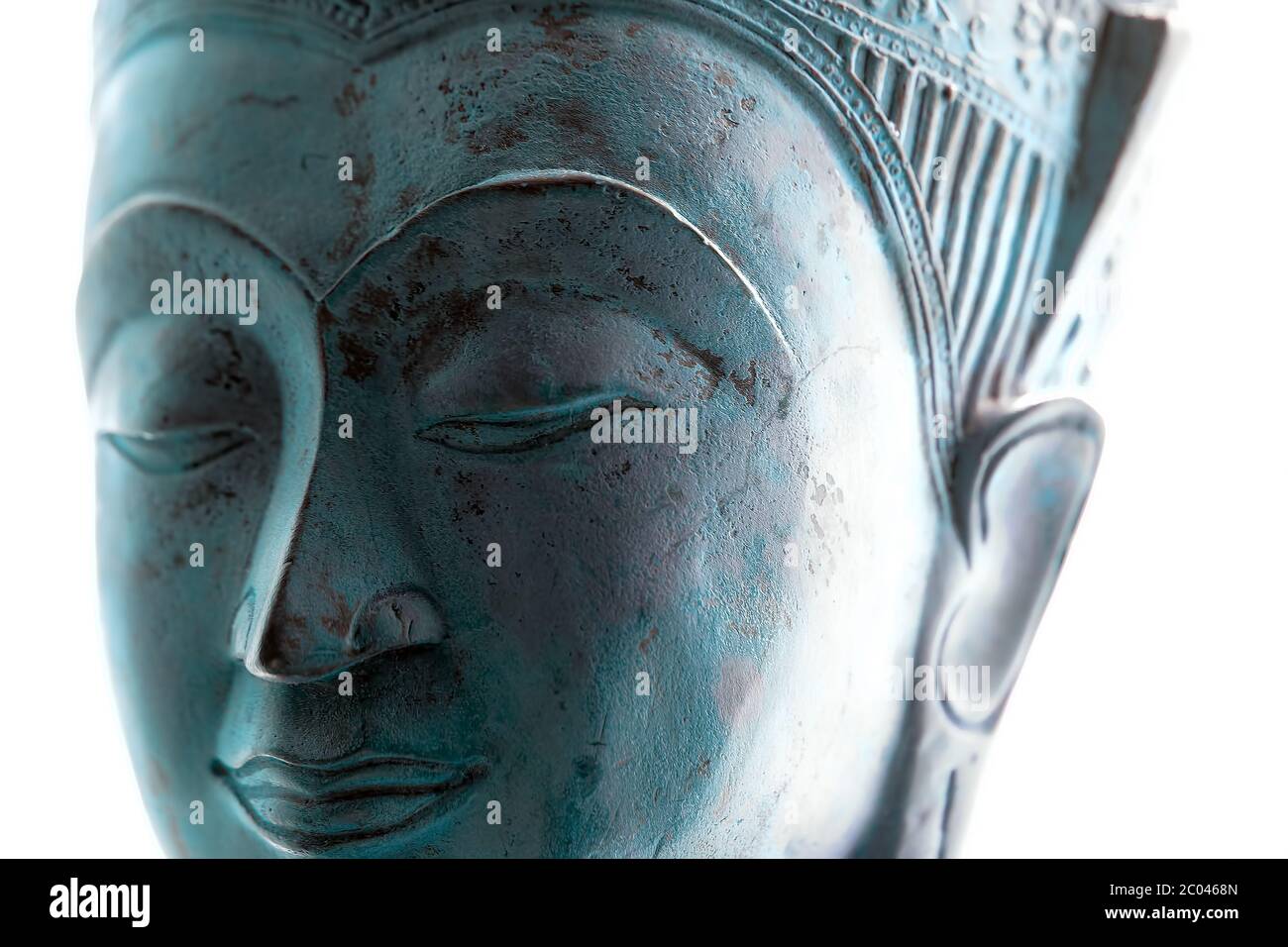 Blaues Buddha-Gesicht. Spiritueller Lebensstil aus nächster Nähe. Weiches selektives Fokusbild der zeitgenössischen buddhistischen Kopfstatue auf weißem Hintergrund. Heiterer Ausdruck Stockfoto