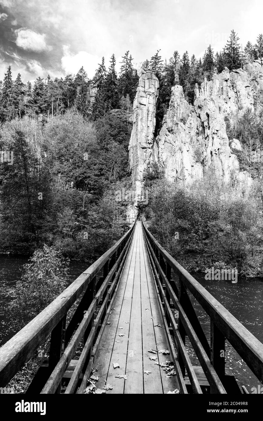 Swing-Brücke über den Fluss Ohre bei Svatos Rocks, Tschechisch: Svatosske skaly, im Herbst, Tschechische Republik. Schwarzweiß-Bild. Stockfoto