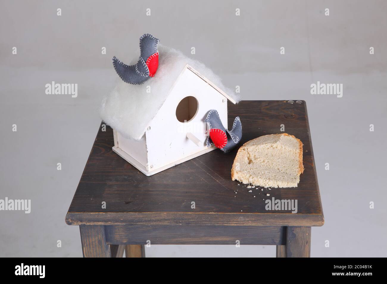 Dekoratives kleines Haus für Birdies und ein Brotstück Stockfoto