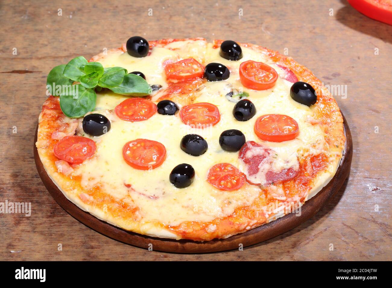 Pizza mit Käse, Salami, Feldpilzen und Oliven Stockfoto