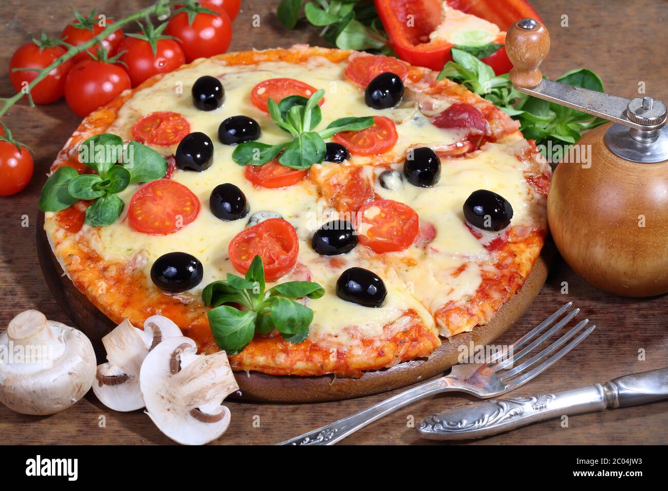 Pizza mit Käse, Salami, Feldpilzen und Oliven Stockfoto