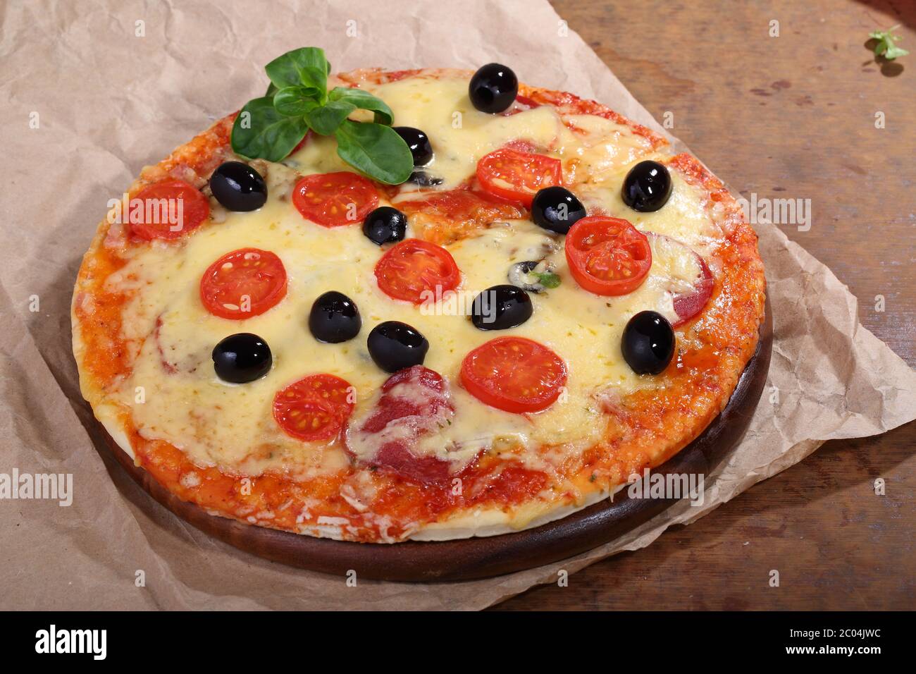 Pizza mit Käse, Salami, Feldpilzen und Oliven Stockfoto