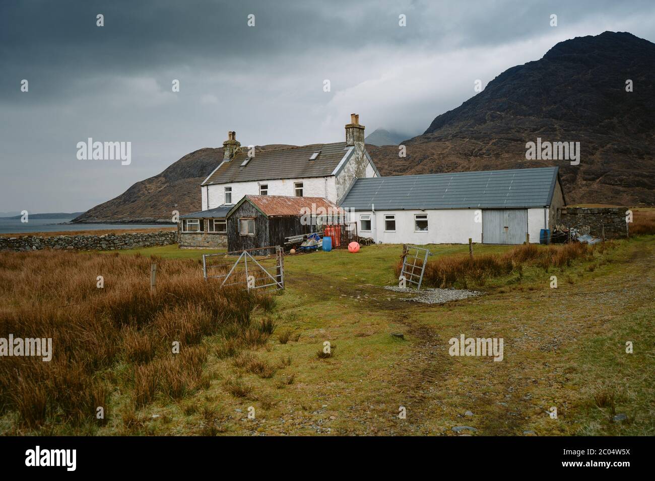 Panoramablick auf die Cuillin Mountains als spektakuläre Kulisse, die isolierte Fischerhütte in Camasunary Bay auf der Isle of Skye Stockfoto