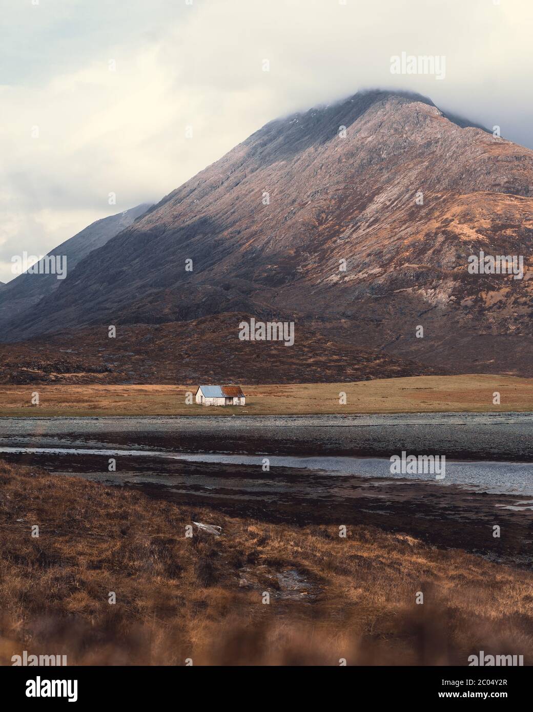 Panoramablick auf die Cuillin Mountains als spektakuläre Kulisse, die isolierte Fischerhütte in Camasunary Bay auf der Isle of Skye Stockfoto