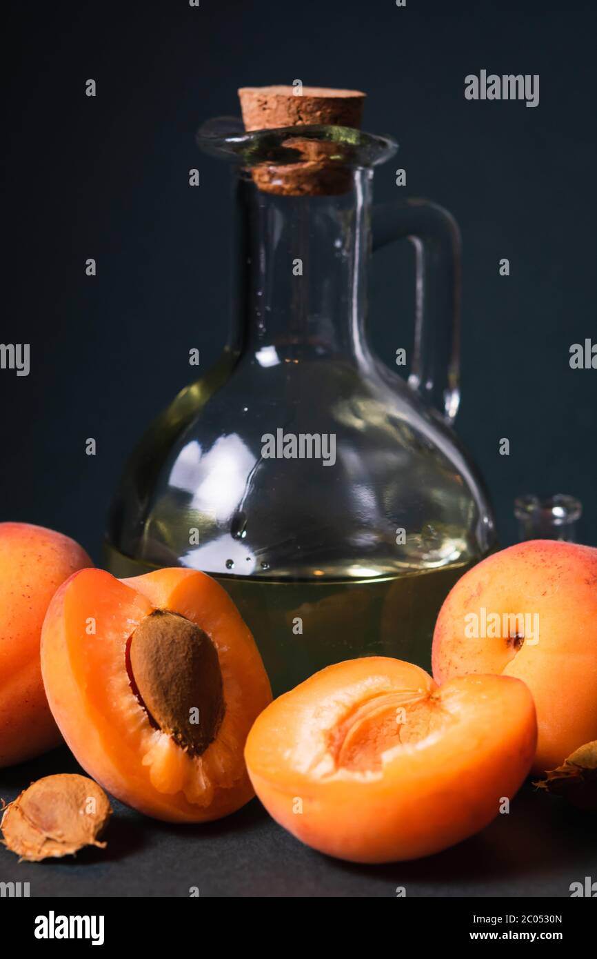 Naturkosmetik Konzept, Aprikosenkernöl auf dunklem Hintergrund Stockfoto