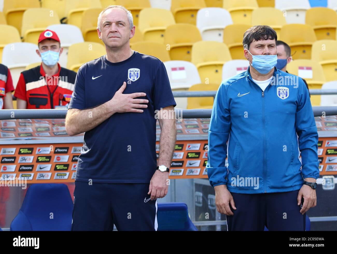 KIEW, UKRAINE - 6. JUNI 2020: Cheftrainer von Desna Tschernihiw Oleksandr Ryabokon (L) hört vor dem Spiel der ukrainischen Premier League gegen Schachtar im Olympiastadion der NSC Stockfoto