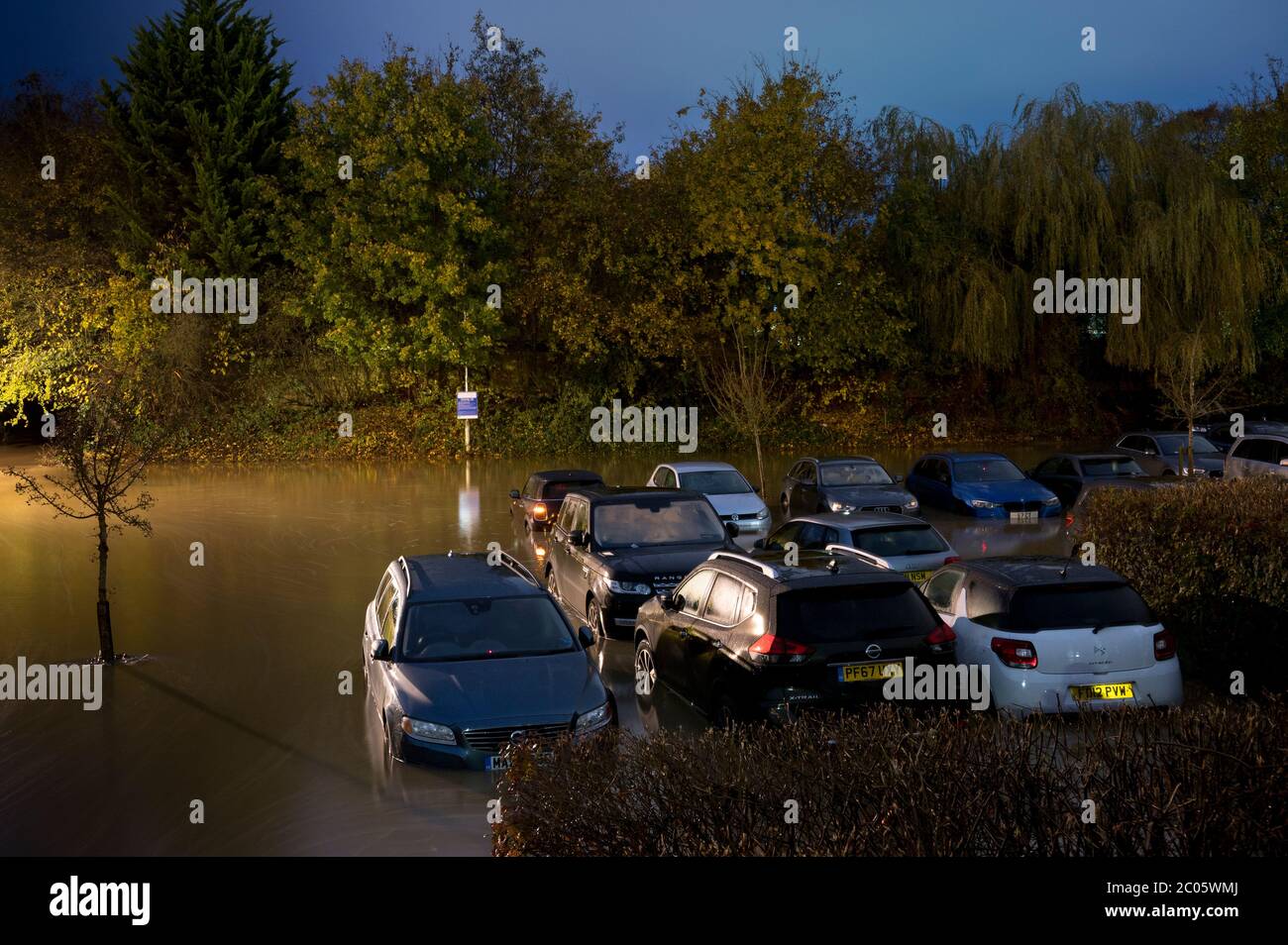 Autos in einem überfluteten Parkplatz in der Nacht in Market Harborough, Leicestershire, England. Stockfoto