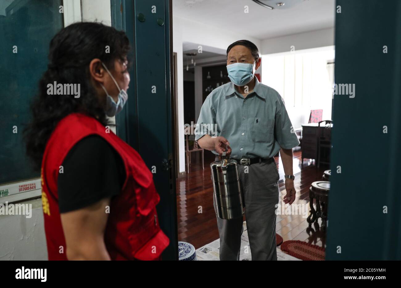 Suzhou, Chinas Provinz Jiangsu. Juni 2020. Wu Siqin (R), 84-jähriger Einwohner der Gemeinde Fengnanlu, erhält am 11. Juni 2020 von dem Sozialarbeiter Wang Linying in Suzhou, der ostchinesischen Provinz Jiangsu, Essen. Die Gemeinde Loufeng im Suzhou Industriepark bietet älteren Menschen, die in der Gemeinde leben, einen Lieferservice für Mahlzeiten an, um den Alten mehr Komfort zu bieten. Kredit: Yang Lei/Xinhua/Alamy Live News Stockfoto
