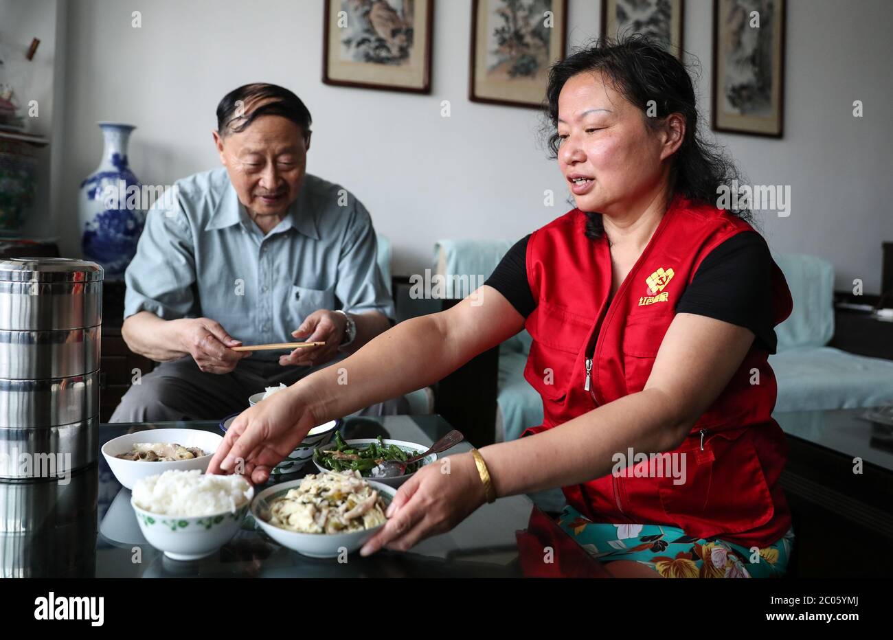 Suzhou, Chinas Provinz Jiangsu. Juni 2020. Wu Siqin (L), 84-jähriger Einwohner der Gemeinde Fengnanlu, erhält am 11. Juni 2020 von dem Sozialarbeiter Wang Linying in Suzhou, der ostchinesischen Provinz Jiangsu, Essen. Die Gemeinde Loufeng im Suzhou Industriepark bietet älteren Menschen, die in der Gemeinde leben, einen Lieferservice für Mahlzeiten an, um den Alten mehr Komfort zu bieten. Kredit: Yang Lei/Xinhua/Alamy Live News Stockfoto