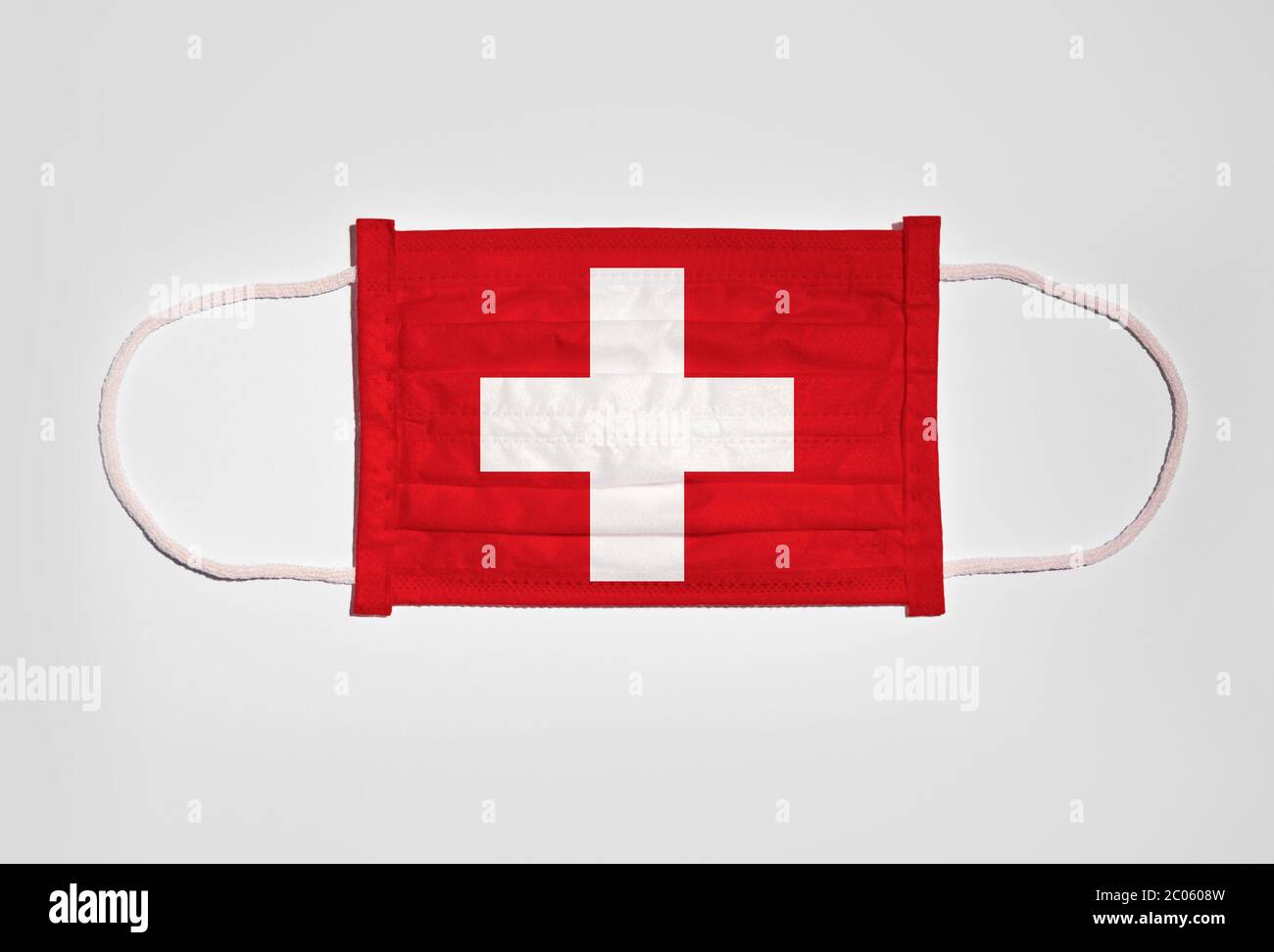 Symbolisches Bild Corona Krise, Mundschutz, Atemschutzmaske, Mund- und Nasenschutz mit Schweizer Flagge, weißer Hintergrund Stockfoto