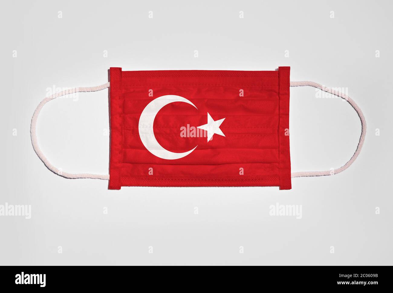 Symbolbild Corona Krise, Mundschutz, Atemmaske, Mundnasenschutz mit Flagge der Türkei, weißer Hintergrund Stockfoto